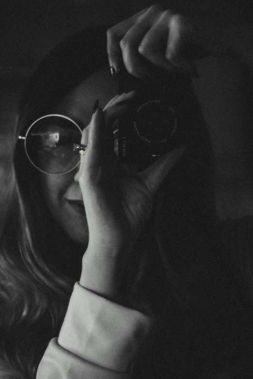 a woman taking a picture with a camera, a black and white photo, by andrei riabovitchev, glasses |, low quality grainy, low-light, medium format