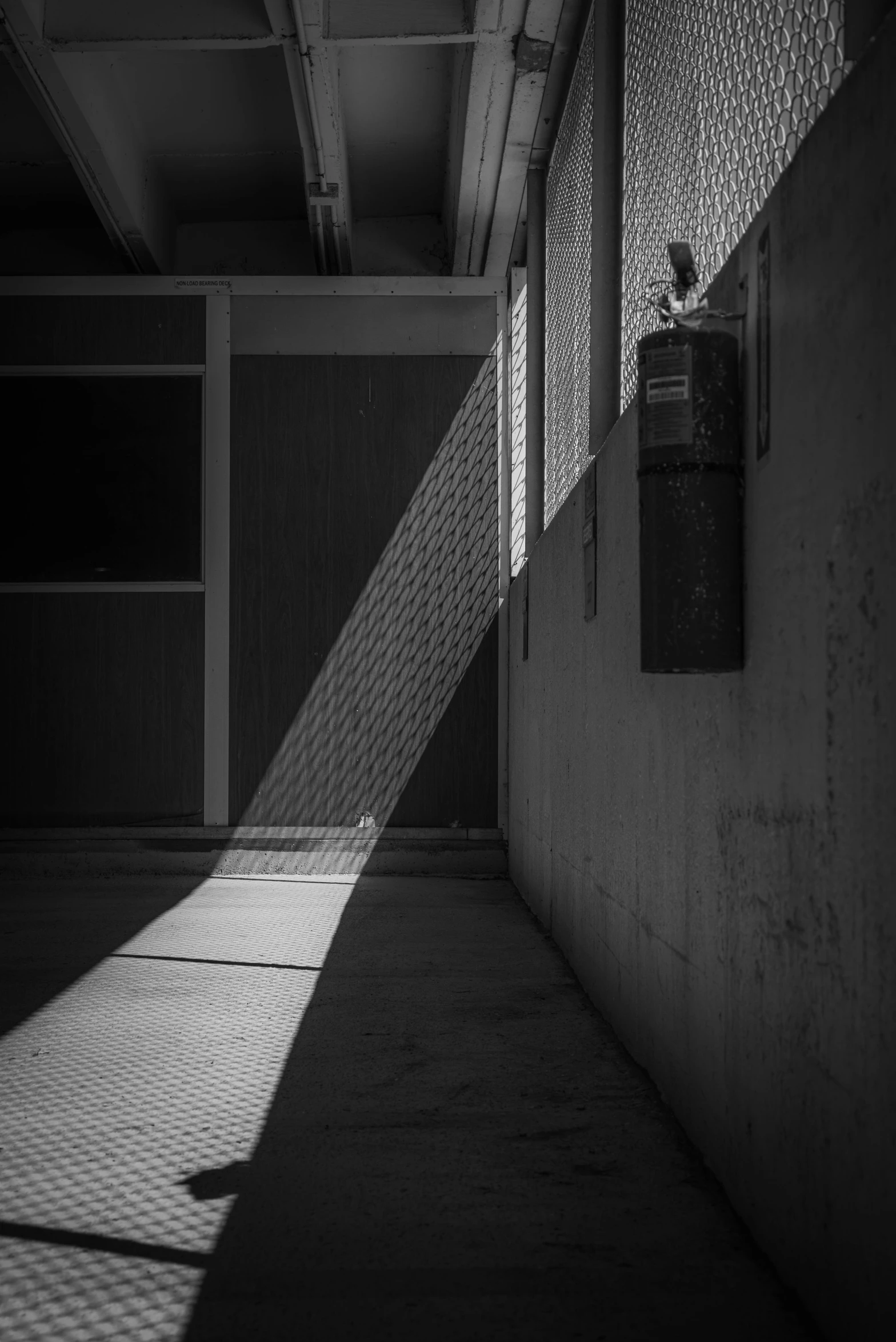 a black and white photo of a hallway, a black and white photo, inspired by Max Dupain, unsplash contest winner, light and space, in front of a garage, sunset. light shadow, natural prison light, abstracted