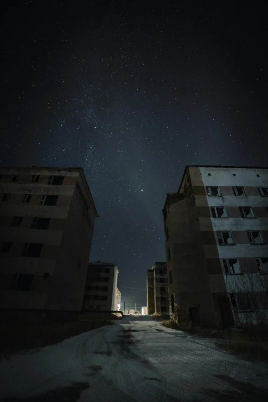 a couple of tall buildings sitting on top of a snow covered ground, an album cover, by Tobias Stimmer, unsplash contest winner, brutalism, dark abandoned hallway at night, ground level view of soviet town, the stars, nuclear aftermath