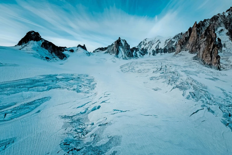 a mountain range covered in snow under a blue sky, by Cedric Peyravernay, unsplash contest winner, surrealism, icy glaciers, ground level shot, chamonix, wide high angle view