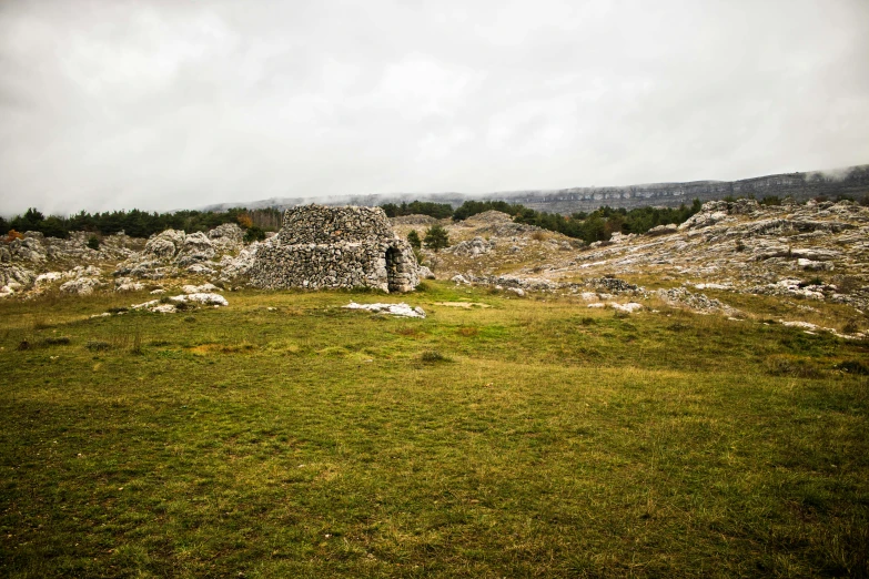 a stone structure sitting on top of a lush green field, unsplash, les nabis, mayo, 2000s photo, ruined city, karst landscape