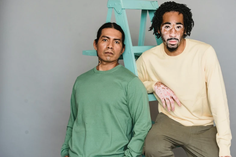 a couple of men standing next to each other, a portrait, pexels contest winner, wearing green clothing, medium skin tone, sitting down, artists