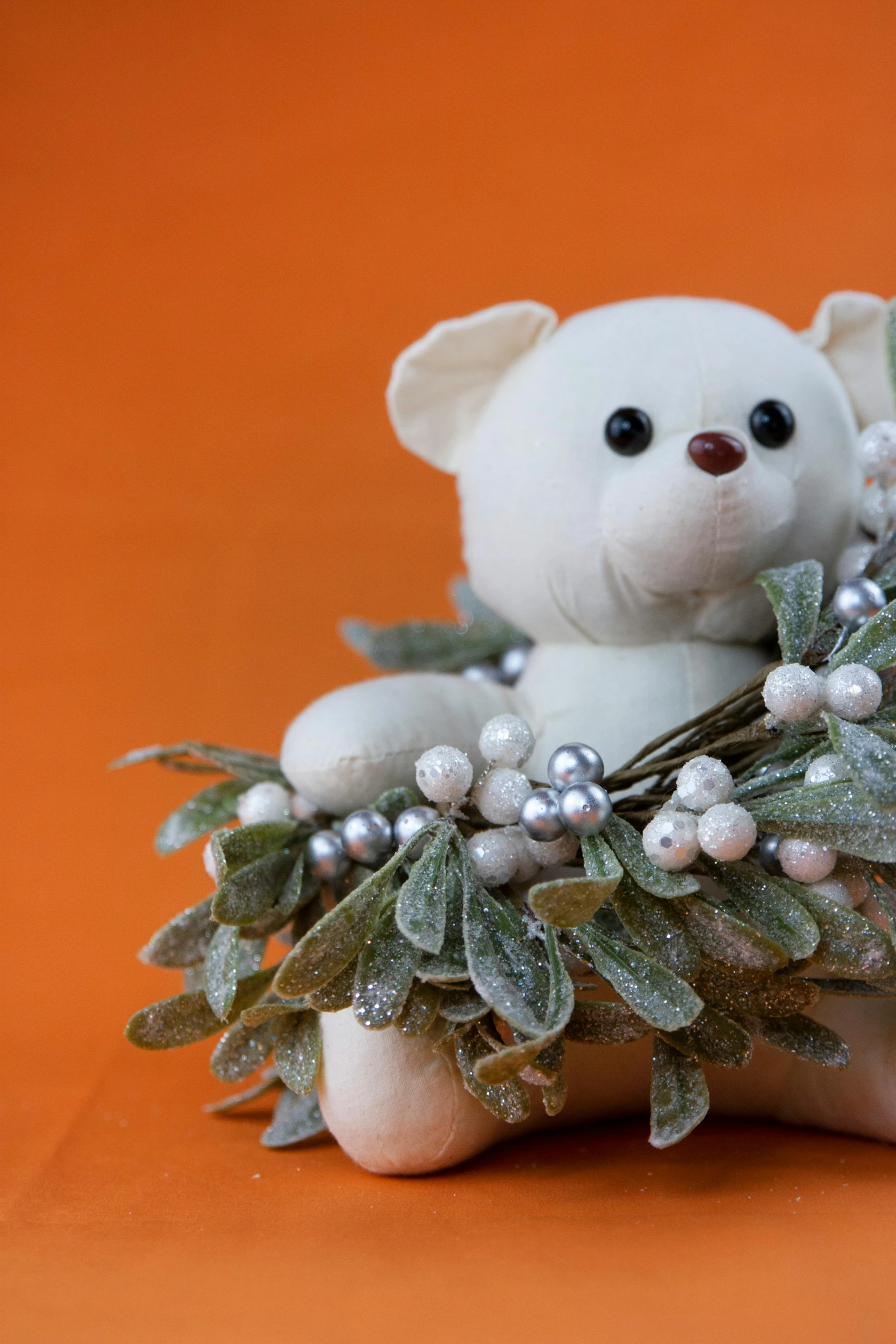 a white teddy bear sitting on top of a christmas wreath, a still life, trending on reddit, romanticism, orange pastel colors, made of felt and cloth and beads, paul barson, eucalyptus