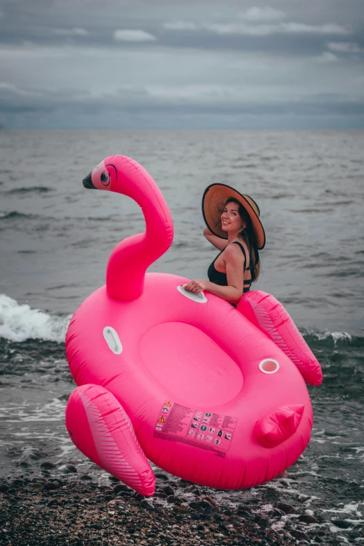 a woman sitting on an inflatable flamingo on the beach, by Julia Pishtar, pexels contest winner, square, low quality photo, tubing, indonesia