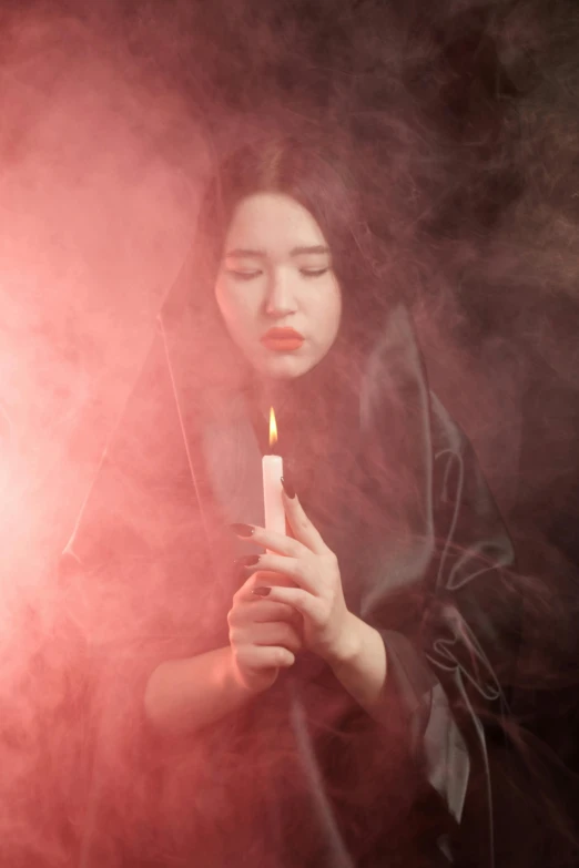 a woman holding a candle in her hands, pexels contest winner, surrealism, cruel korean goth girl, with red haze, wearing dark robe, 2019 trending photo