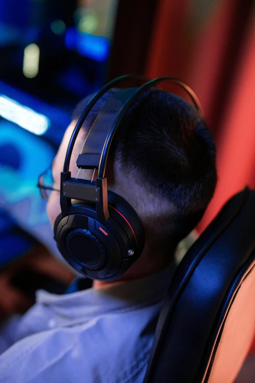 a man sitting in front of a computer wearing headphones, skin on the gaming pc, profile image, neck zoomed in, bottom angle