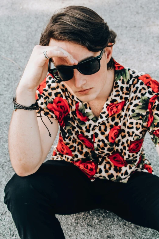 a man sitting on the ground with a skateboard, an album cover, trending on pexels, renaissance, hawaiian shirt, profile image, lachlan bailey, with sunglass