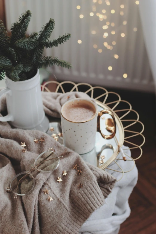 a cup of coffee sitting on top of a table, by Julia Pishtar, trending on pexels, romanticism, festive atmosphere, ivory and copper, starlight, casually dressed