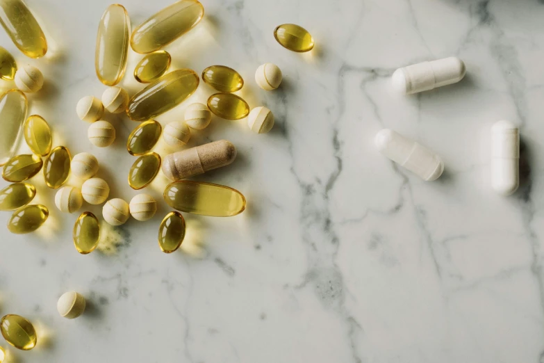 a bunch of pills sitting on top of a marble counter, by Emma Andijewska, botanicals, yellow, premium quality, multiple lights