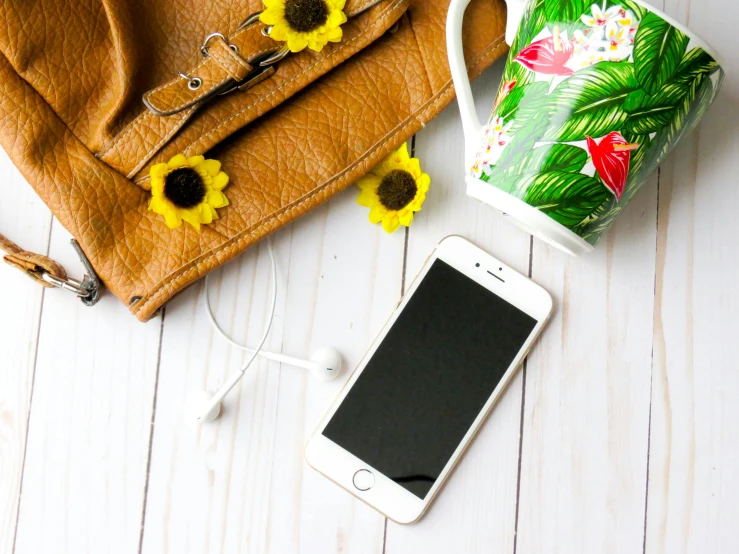 a cell phone sitting on top of a table next to a purse, trending on pexels, sunflower background, flatlay, white backround, flowery wallpaper