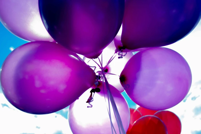 a bunch of purple and red balloons in the sky, an album cover, pexels, at a birthday party, ((purple)), overexposed photograph, various colors