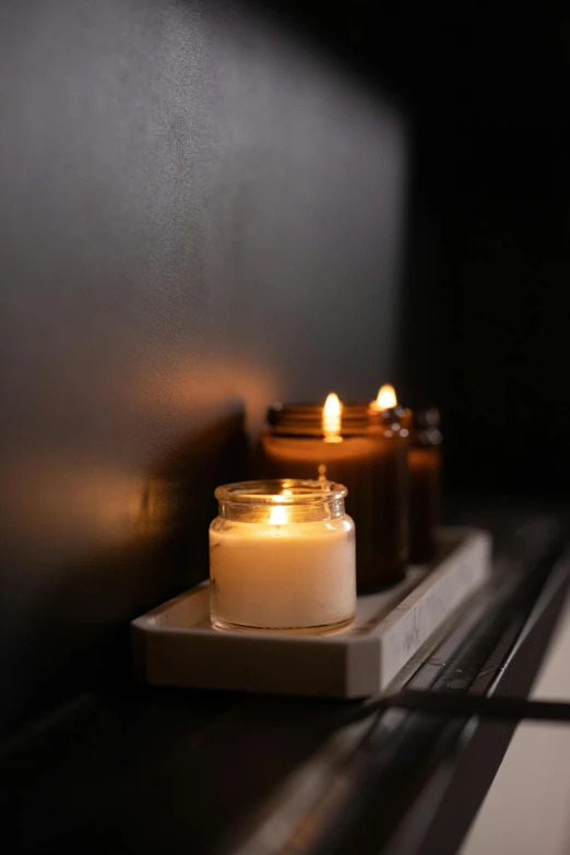 a couple of candles sitting on top of a window sill, unsplash, minimalism, multiple stories, on the altar, dwell, soft lighting