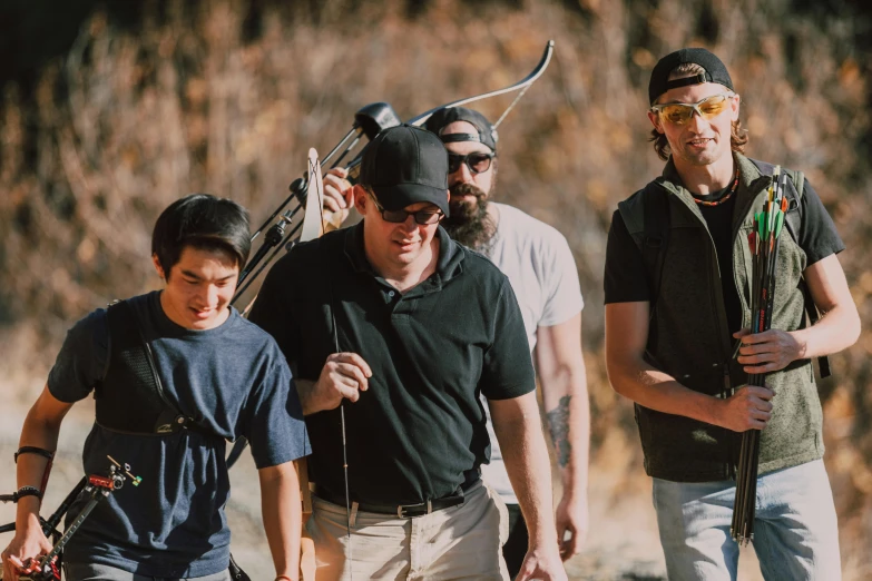 a group of men standing next to each other, pexels contest winner, holding a crossbow, wearing sunglasses and a cap, lachlan bailey, avatar image