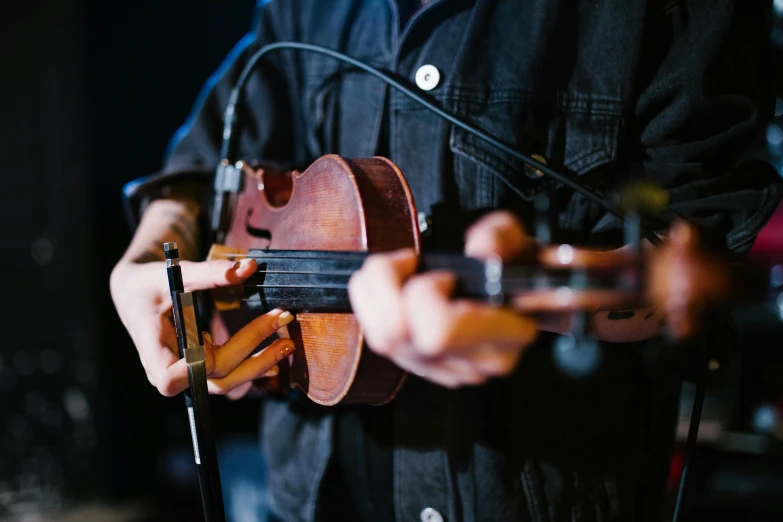 a close up of a person holding a violin, holding guitars, profile image, concert, low colour