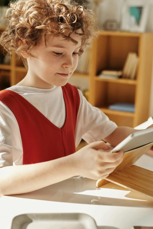 a young boy sitting at a table reading a book, a digital rendering, pexels, happening, 2 5 6 x 2 5 6 pixels, took on ipad, a broad shouldered, bl