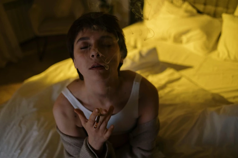 a woman sitting on a bed with her eyes closed, inspired by Nan Goldin, pexels contest winner, serial art, cigarette in his mouth, sophia lillis, still from loki ( 2 0 2 1 ), lights off