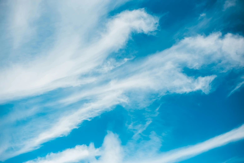 a man riding a snowboard on top of a snow covered slope, an album cover, by Rachel Reckitt, pexels contest winner, minimalism, wispy clouds in a blue sky, cirrus clouds, alcohol with blue delirium skies, sky mural on the room ceiling