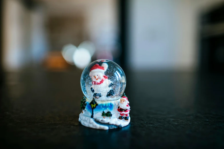 a snow globe sitting on top of a table, front facing the camera, mini figure, multicoloured, at home