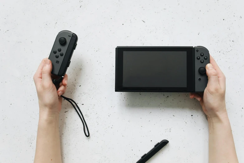 a person holding a nintendo wii game controller, unsplash, visual art, all black matte product, nintendo switch, half - length photo, professional product photo