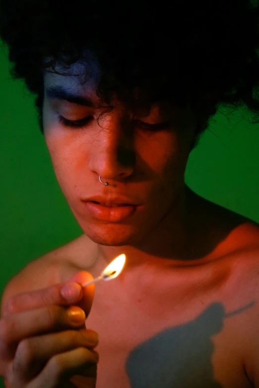 a close up of a person holding a lit candle, inspired by Nan Goldin, magic realism, young spanish man, ganja, he is about 20 years old | short, lgbt