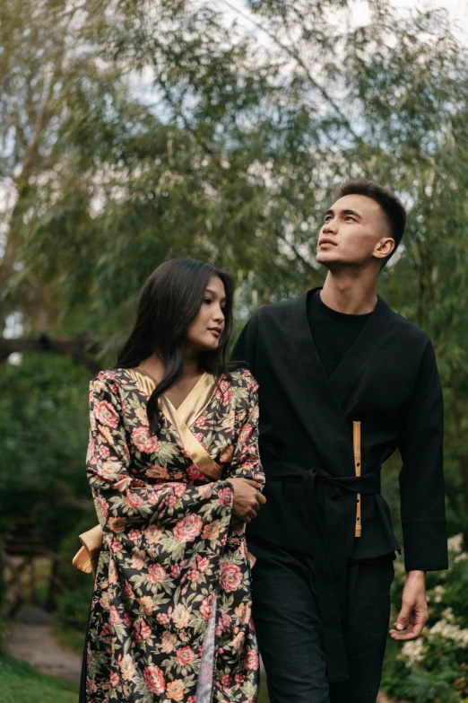 a man and a woman walking down a path, a portrait, by Basuki Abdullah, unsplash, renaissance, casual black clothing, floral clothes, handsome, long sleeves
