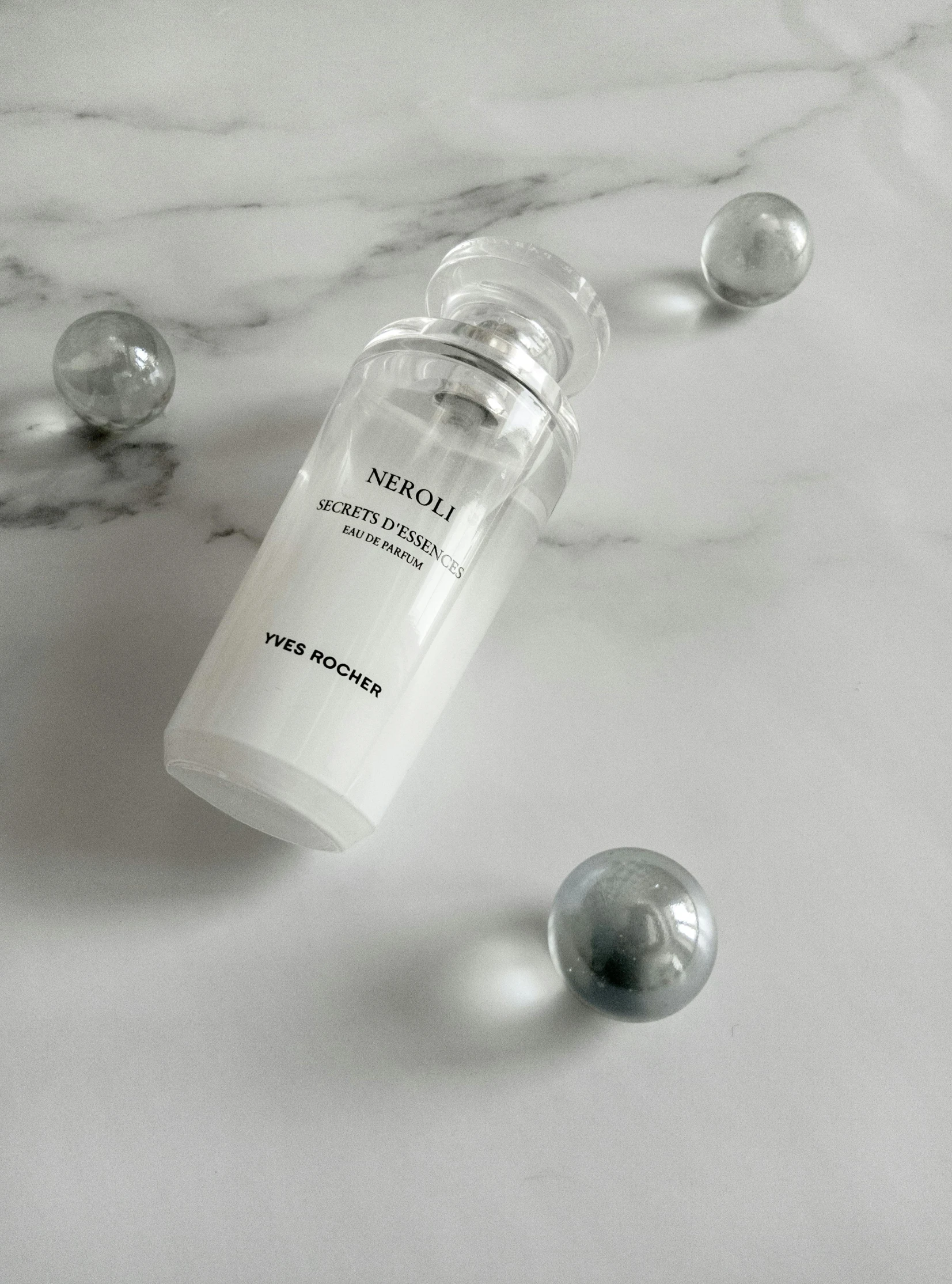 a bottle of liquid sitting on top of a marble counter, inspired by Ugo Nespolo, dewy skin, translucent orbs, hera, product view