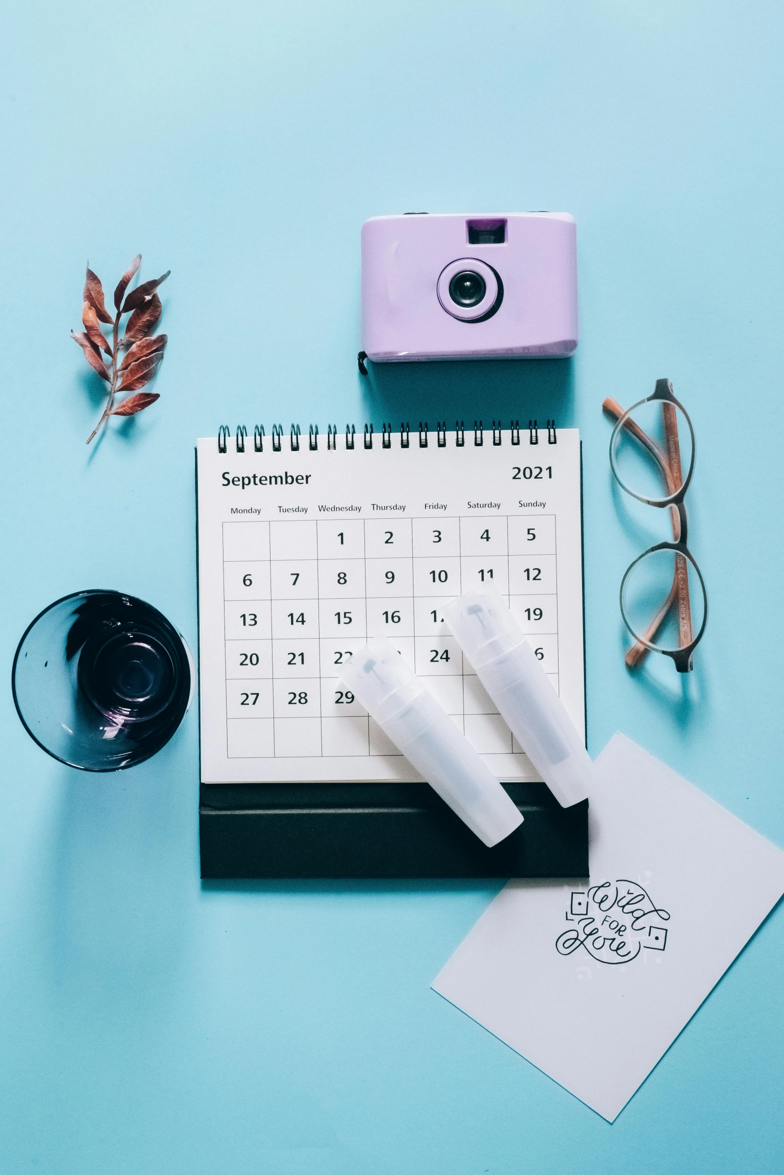 a camera sitting on top of a desk next to a calendar, hydration, thumbnail, various items, detailed product image