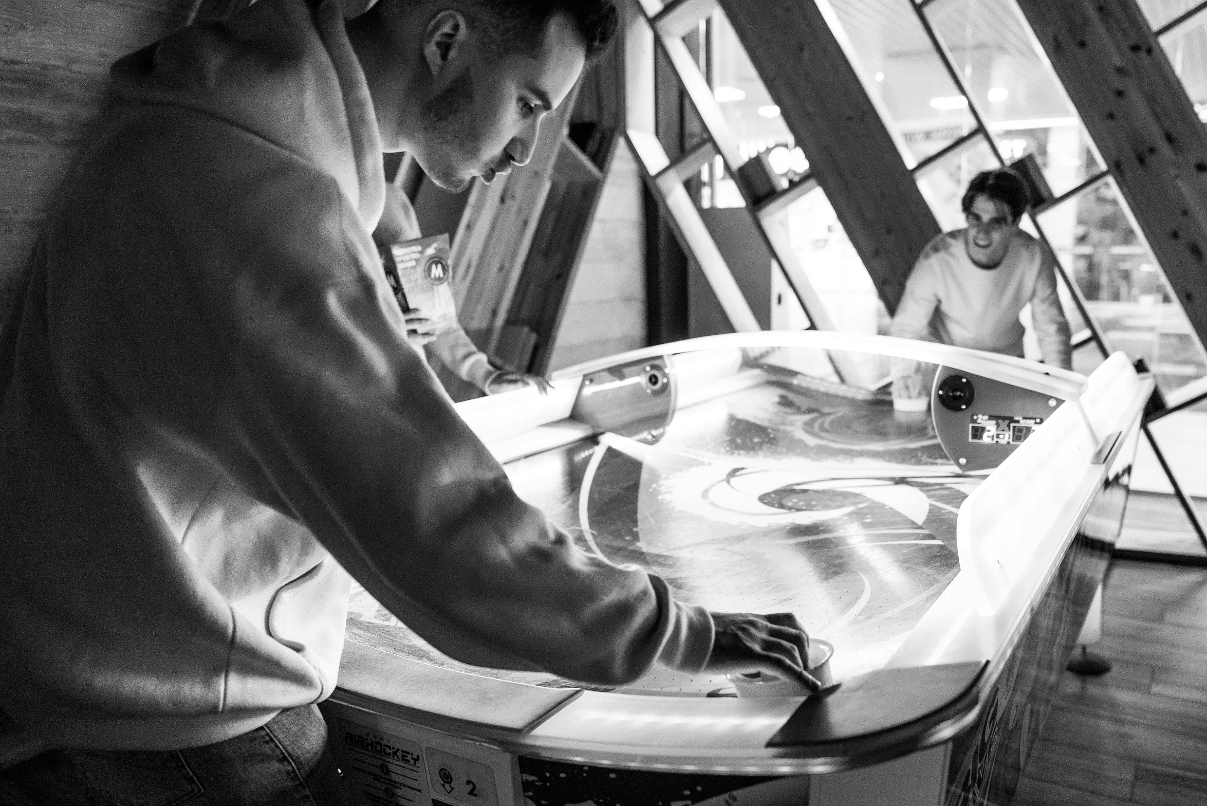 a black and white photo of a man working on a surfboard, a silk screen, by Raphaël Collin, pexels, process art, reflections on a glass table, gaming, ice - carving, digital art #oneshotgame