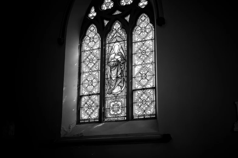 a black and white photo of a stained glass window, a black and white photo, by Joy Garnett, pexels, virgin mary, broken stained glass windows, first light, glass window