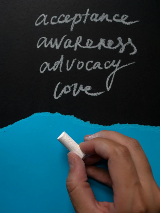 a person writing on a blackboard with chalk, awareness, thumbnail, ribbon, love
