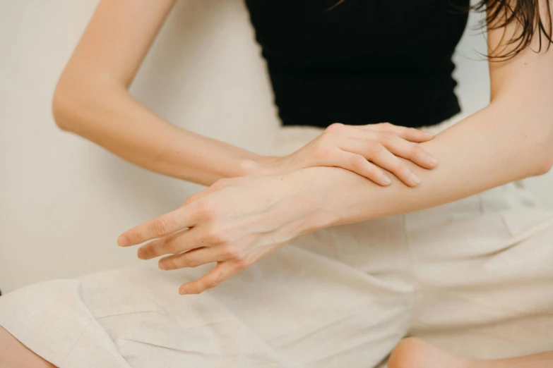 a close up of a person touching a person's hand, by Emma Andijewska, trending on pexels, renaissance, pretty face with arms and legs, recovering from pain, folded arms, open palm