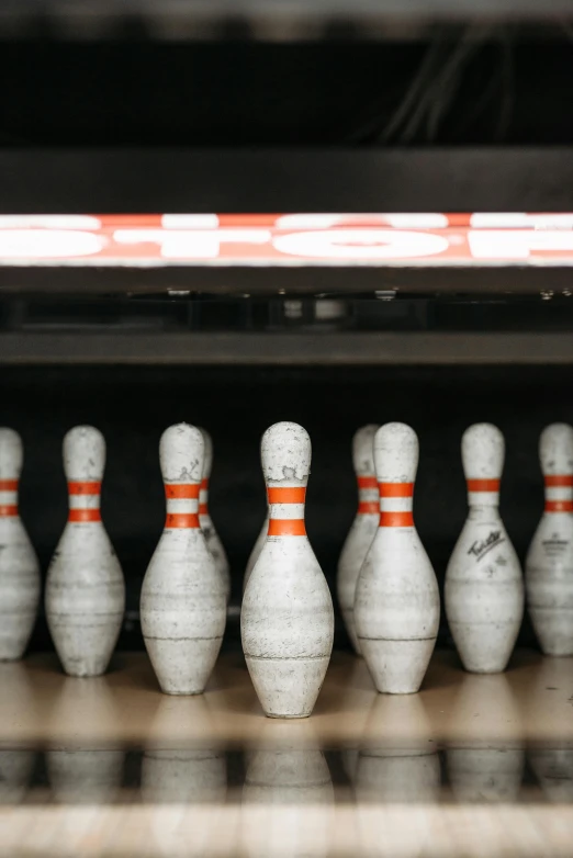 a row of bowling pins sitting on top of a wooden floor