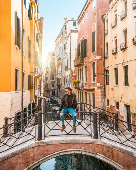 a man sitting on a bridge in venice, pexels contest winner, lgbtq, standing outside a house, floating over a city sidewalk, about to step on you