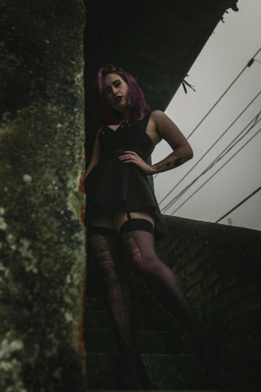 a woman with purple hair is posing for a picture, an album cover, unsplash, wearing a dark dress, perched in a tree, thigh highs, pov photo