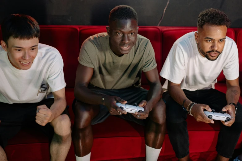 a group of young men sitting on top of a red couch, pexels, realism, holding controller, ea sport, black man, promotional image