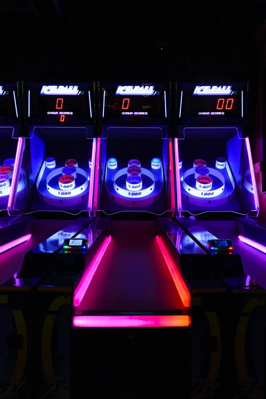 a row of arcade games sitting on top of a table, flashing lights