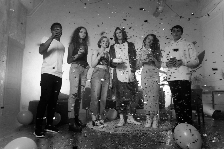 a group of people standing in a room covered in confetti, a black and white photo, teenagers, hq 8k scan, splashes, group