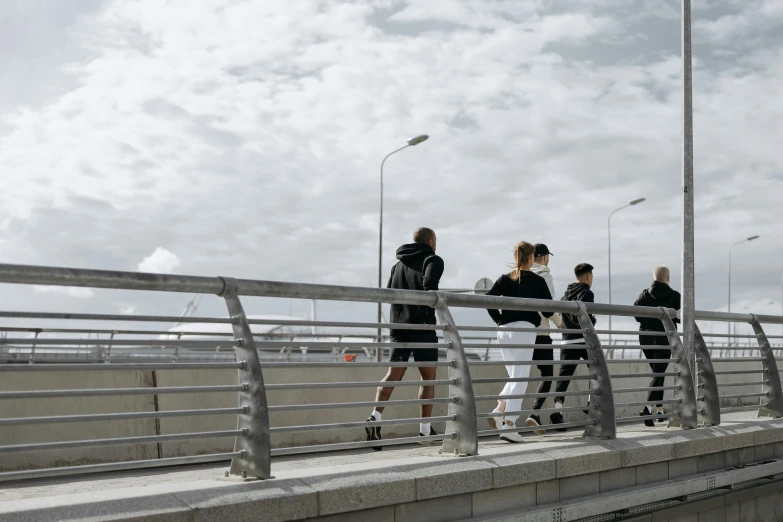 a group of people walking across a bridge, by Nina Hamnett, happening, sports clothing, neo norilsk, grey, high-resolution