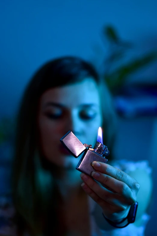 a woman holding a lighter in her hand, an album cover, inspired by Elsa Bleda, pexels contest winner, blue and purple vapor, chemistry, quiet intensity, thc