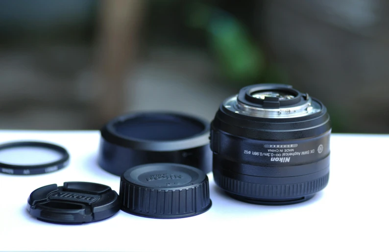 a camera lens sitting on top of a table, sigma 2 8 mm, micro macro auto focus, nikkon, dof and bokeh