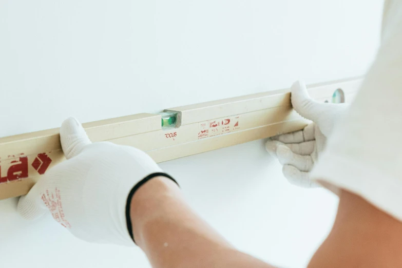 a close up of a person holding a piece of wood, white walls, surgical supplies, rectangle, maintenance