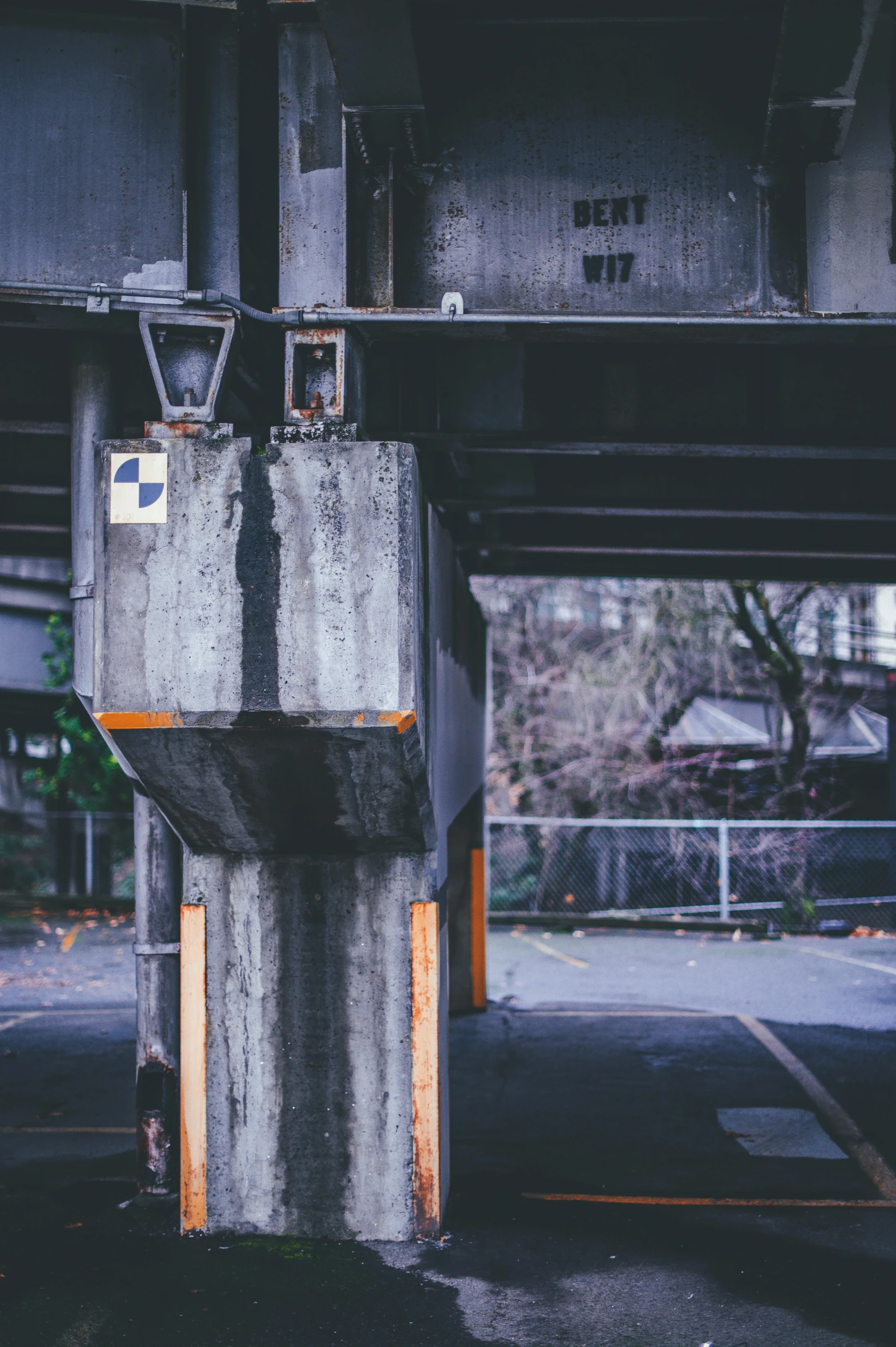 a motorcycle parked under a bridge in a parking lot, an album cover, unsplash, brutalism, metal joints, structures, deserted shinjuku junk, parkour