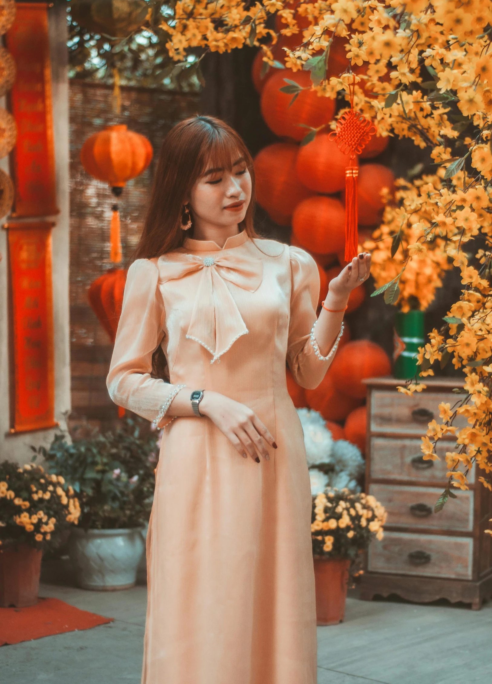 a woman standing in front of a tree with yellow flowers, a picture, by Tan Ting-pho, pexels contest winner, toned orange and pastel pink, bowknot, wearing festive clothing, dang my linh