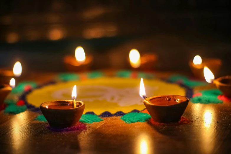 a group of lit candles sitting on top of a table, a picture, trending on pexels, visual art, symmetric indian pattern, flares, avatar image, festive