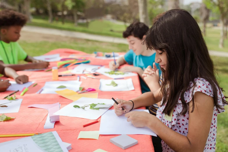 a group of children sitting at a table working on crafts, a child's drawing, by Alejandro Obregón, sunny day in a park, avatar image, promo image