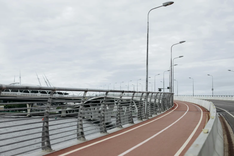 a man riding a skateboard on top of a bridge, by Okada Hanko, unsplash, hurufiyya, empty streetscapes, overcast day, bicycles, floating power cables