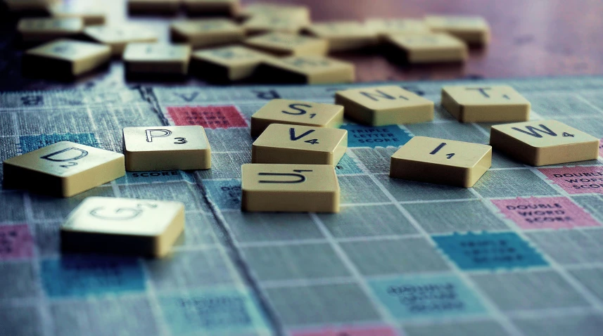 a wooden scrabble game with lots of tiles on it