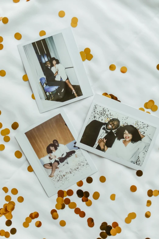 three polaroids sitting on top of a bed covered in confetti, a polaroid photo, white and gold color palette, sza, couple on bed, good times