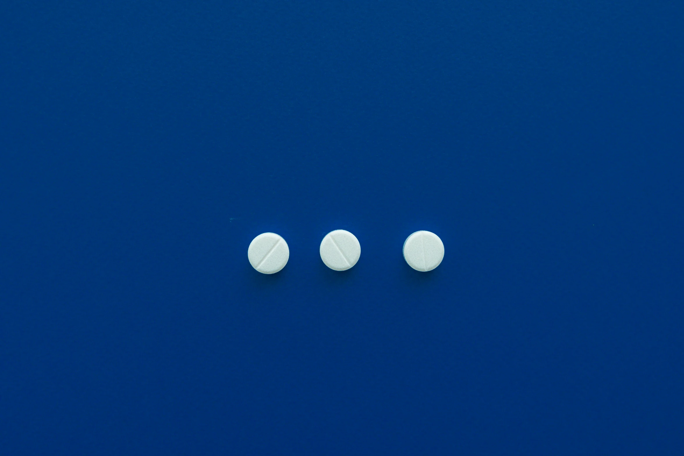 three white pills sitting on top of a blue surface, by Jan Rustem, plasticien, 5 mm, white finish, 3 mm, screw