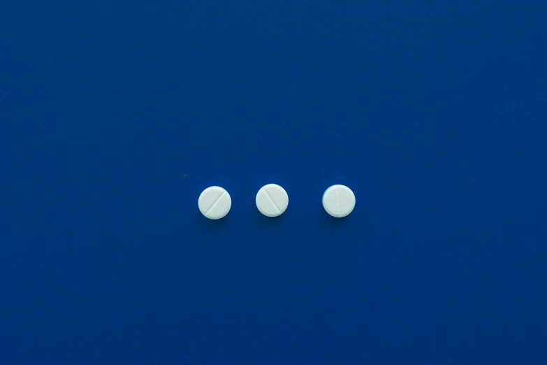 three white pills sitting on top of a blue surface, by Jan Rustem, plasticien, 5 mm, white finish, 3 mm, screw